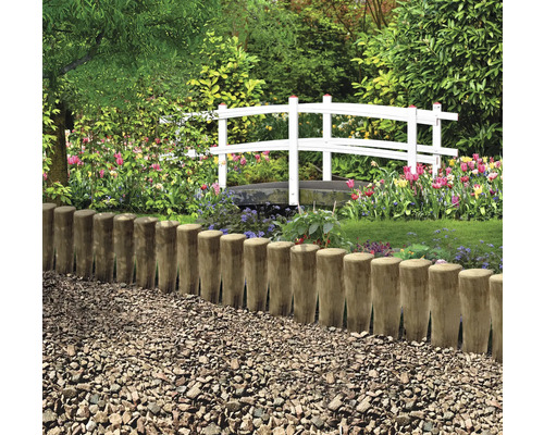 Trädgårdslandskap med trästaket och vit bro