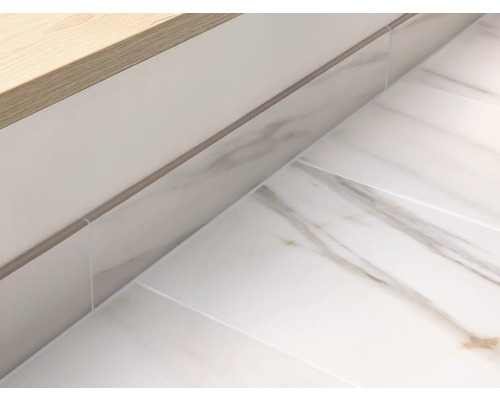 Detaljbild av ett ljust badrum med marmorplattor och tvättställ