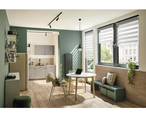 Vardagsrumskök med matbord, stolar, bänk och fönster med rullgardin