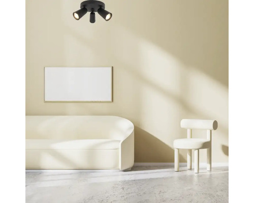 Taklampa med tre spotlights i ett ljust vardagsrum