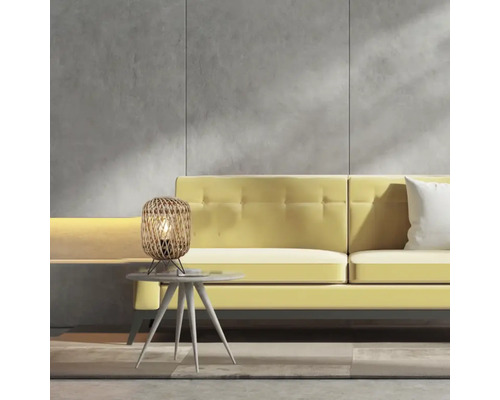 Scen med bordslampa i rotting på ett sidobord framför en gul soffa.