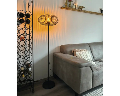 Golvlampa med trådskärm och vinställ i vardagsrummet