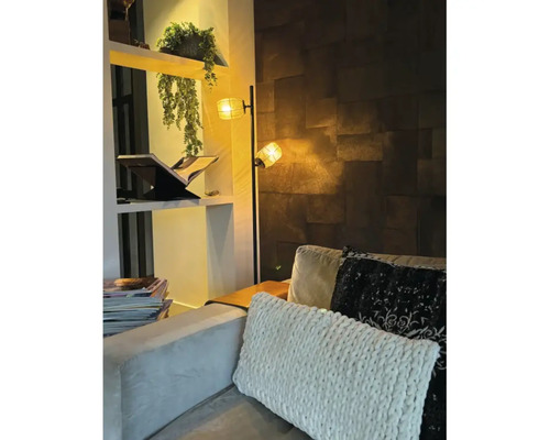 Vardagsrum med golvlampa, hylla och kuddar i soffan.