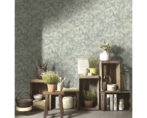 Vardagsrum med blommönstrad tapet, trälådor och dekorativa föremål.