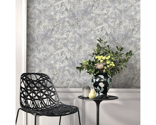 Scen med mönstrad tapet, stol och bord med blomstervas