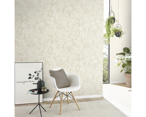 Vardagsrum med mönstrad tapet, stol, sidobord och krukväxter.