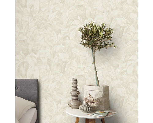 Ett sovrum med en vägg med en tapet med bladtryck.