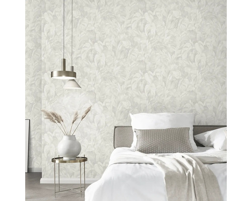 Sovrum med säng, sänglampa och tapet med bladmönster