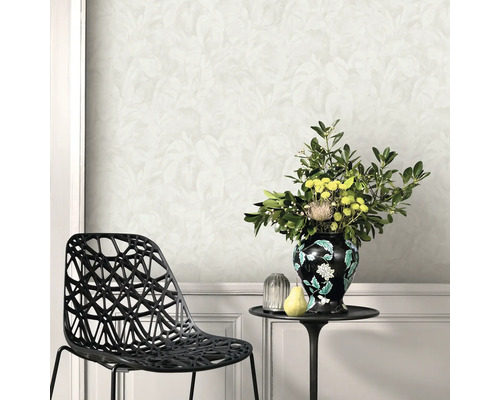 Väggdekoration med blommigt tapetmönster, kombinerat med en svart stol och ett sidobord med en blomvas