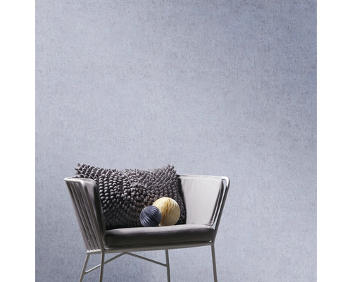 Fåtölj med kudde och dekorativa bollar framför en vägg