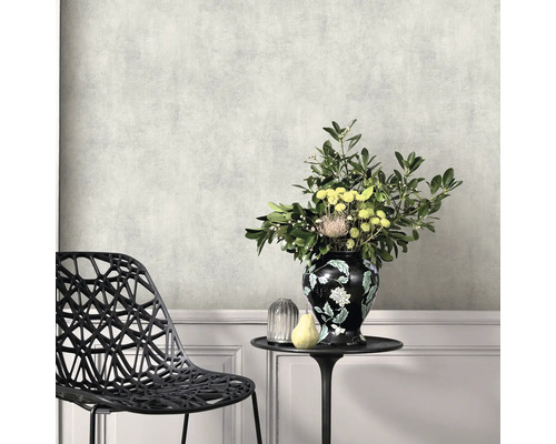 Miljöbild med mönstrad tapet, stol, bord och blomvas