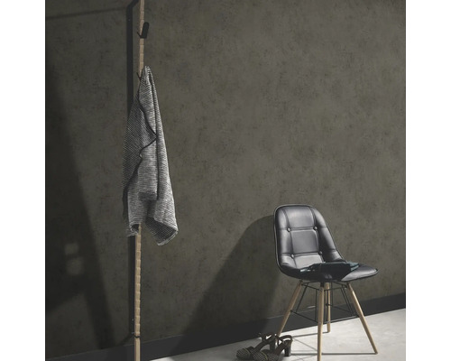 Rumsscen med klädhängare, jacka, stol och skor framför en mörk vägg