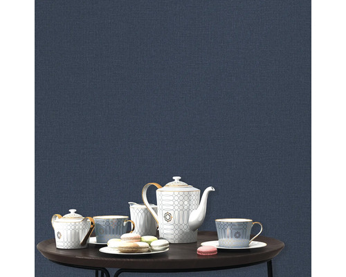 Theservice och makroner på ett bord framför en blå vägg