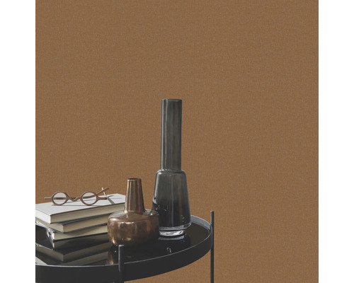 Närbild av brun textilväggbeklädnad med föremål på ett bord