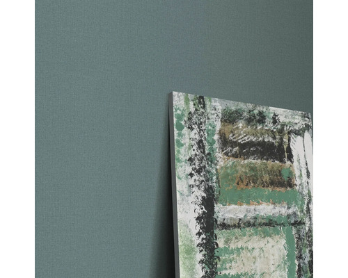 Närbild av en vägg med en duk och en abstrakt målning.