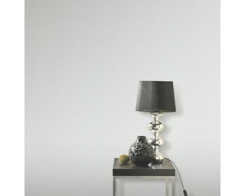 Scen med en bordslampa, en vas och en dekorativ boll på ett sidobord.