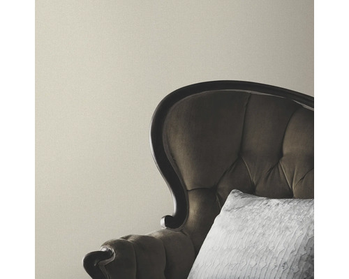 Beige vägg med fåtölj och kudde