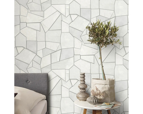 Väggdekoration med geometriskt mönster, säng och dekoration på ett bord