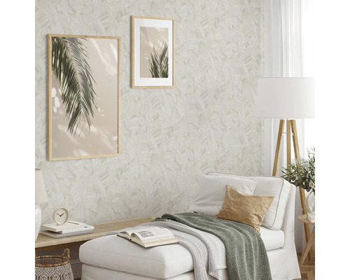 Vardagsrum med mönstrad tapet, två inramade bilder och vit soffa.