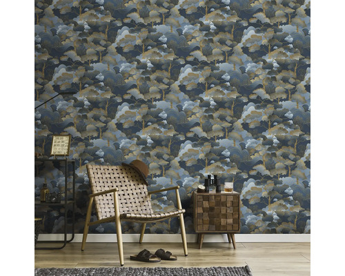 Rumsöversikt med mönstrad tapet, fåtölj och sidobord