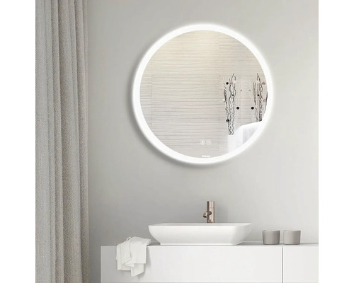 Badrumsscen med en rund spegel med LED-belysning ovanför ett handfat