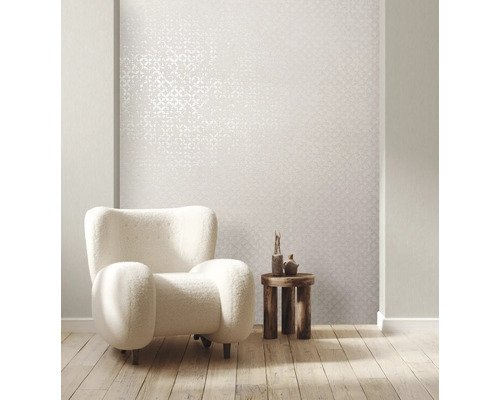 Ljust vardagsrum med mönstrad tapet, fåtölj och sidobord