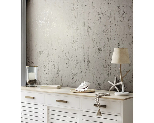 Dekorativ inredning med mönstrad tapet, byrå och lampa