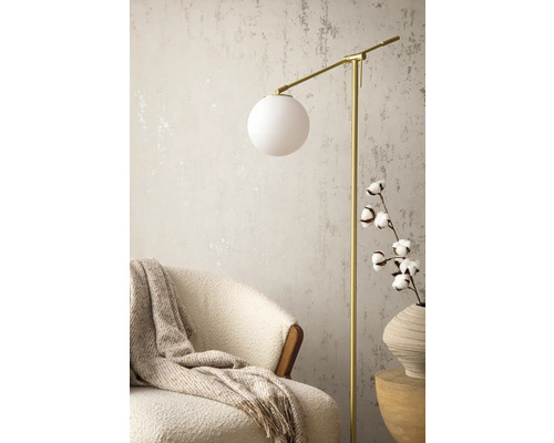 Scen med golvlampa, fåtölj, ullfilt och bomullskvist i vas