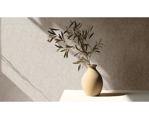 Dekorativa grenar i en keramisk vas på ett bord