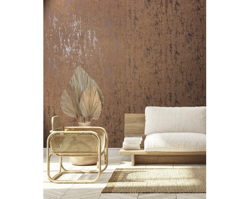 Vardagsrum med brun mönstrad tapet, rottingfåtölj och beige soffa