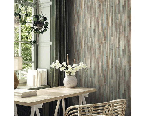 Vardagsrum med träpanel, skrivbord och krukväxter för en mysig atmosfär.