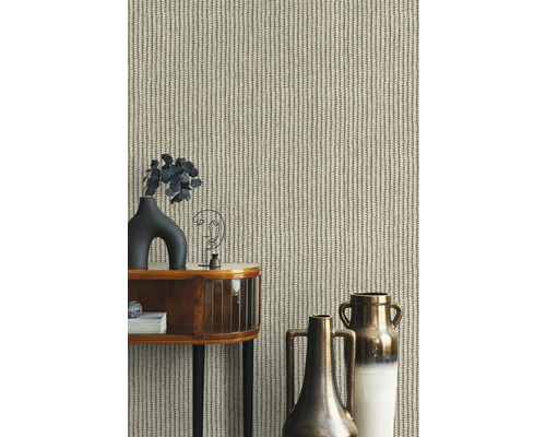 Närbild av en beige tapet med stickat mönster bakom ett dekorerat bord