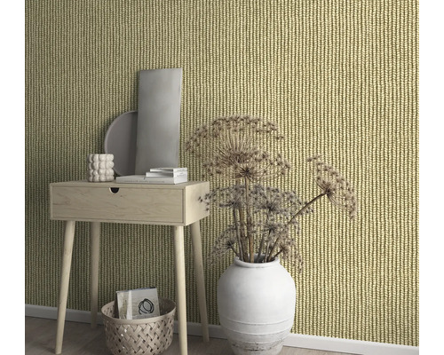 Dekorativt rum med stickad tapet, bord och vas.