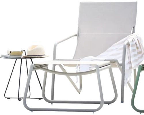 Trädgårdsscen med solstol, pall, sidobord, handduk och hatt