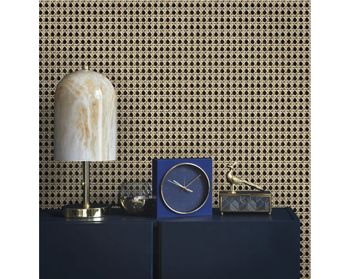 Inredningsidé med rottingtapet, lampa, klocka och dekoration på ett skåp