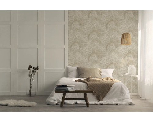 Ljust sovrum med mönstrad tapet, säng och träpall