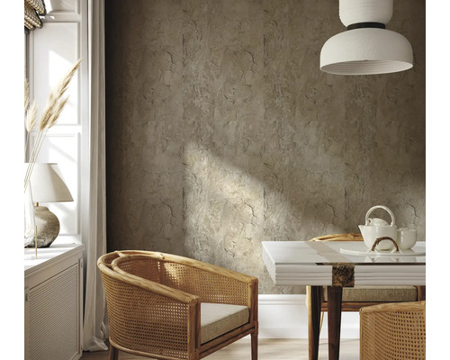 Vardagsrum med väggplattor i stenimitation, rottingfåtöljer och matbord med teservis.