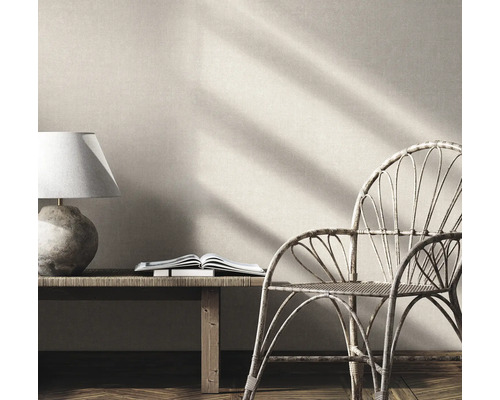 Inredningsscen med lampa, bok och rottingstol
