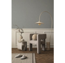 Vardagsrum med fåtölj, golvlampa, sidobord, dekoration och matta för en mysig atmosfär