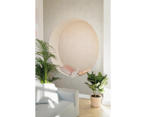 Vardagsrum med månskärformad hängmatta, kuddar, filt, soffa och krukväxter.