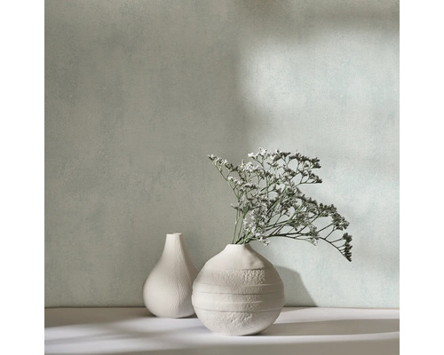 Två dekorativa vaser med torkade blommor framför en vägg