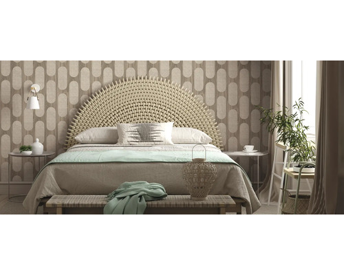 Ljust sovrum med flätad sänggavel, mönstrad tapet och dekorativa element.