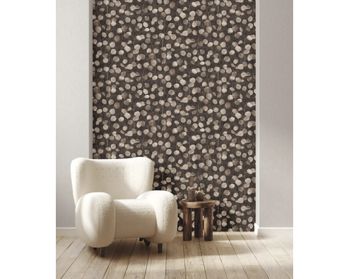 Rumsöversikt med tapet med bladmönster, fåtölj och sidobord