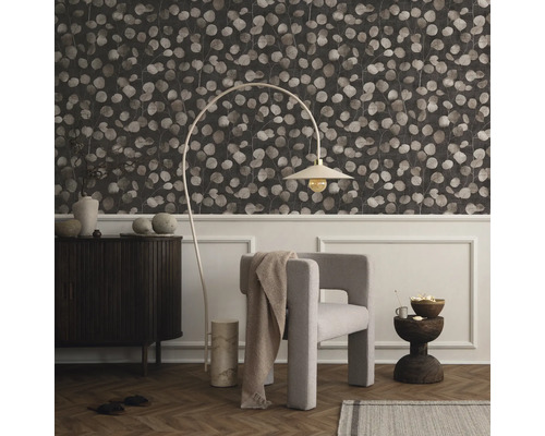 Vardagsrum med mönstrad tapet, fåtölj, golvlampa och byrå