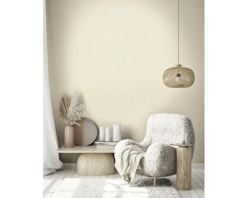 Ljust vardagsrum med fåtölj, sidobord och taklampa