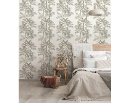 Dekorativt rum med tapet med palmmönster, säng och stol