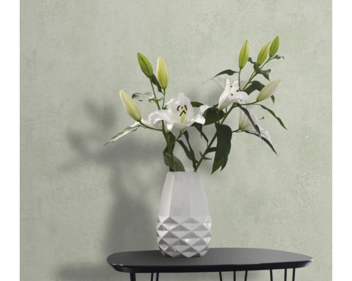 Stilleben med vita liljor i en vit vas på ett bord