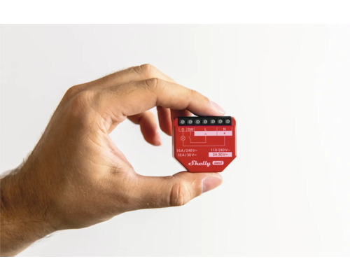 En hand håller en Shelly Gen3 Smart Home-brytare.