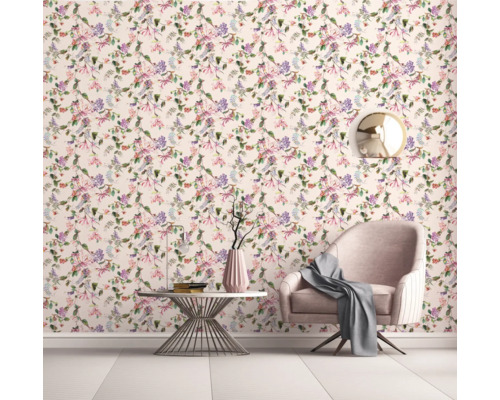 Dekorativt vardagsrum med blommig tapet, fåtölj och sidobord.