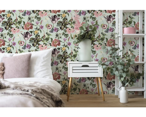 Sovrum med blommig tapet, sängbord och hylla